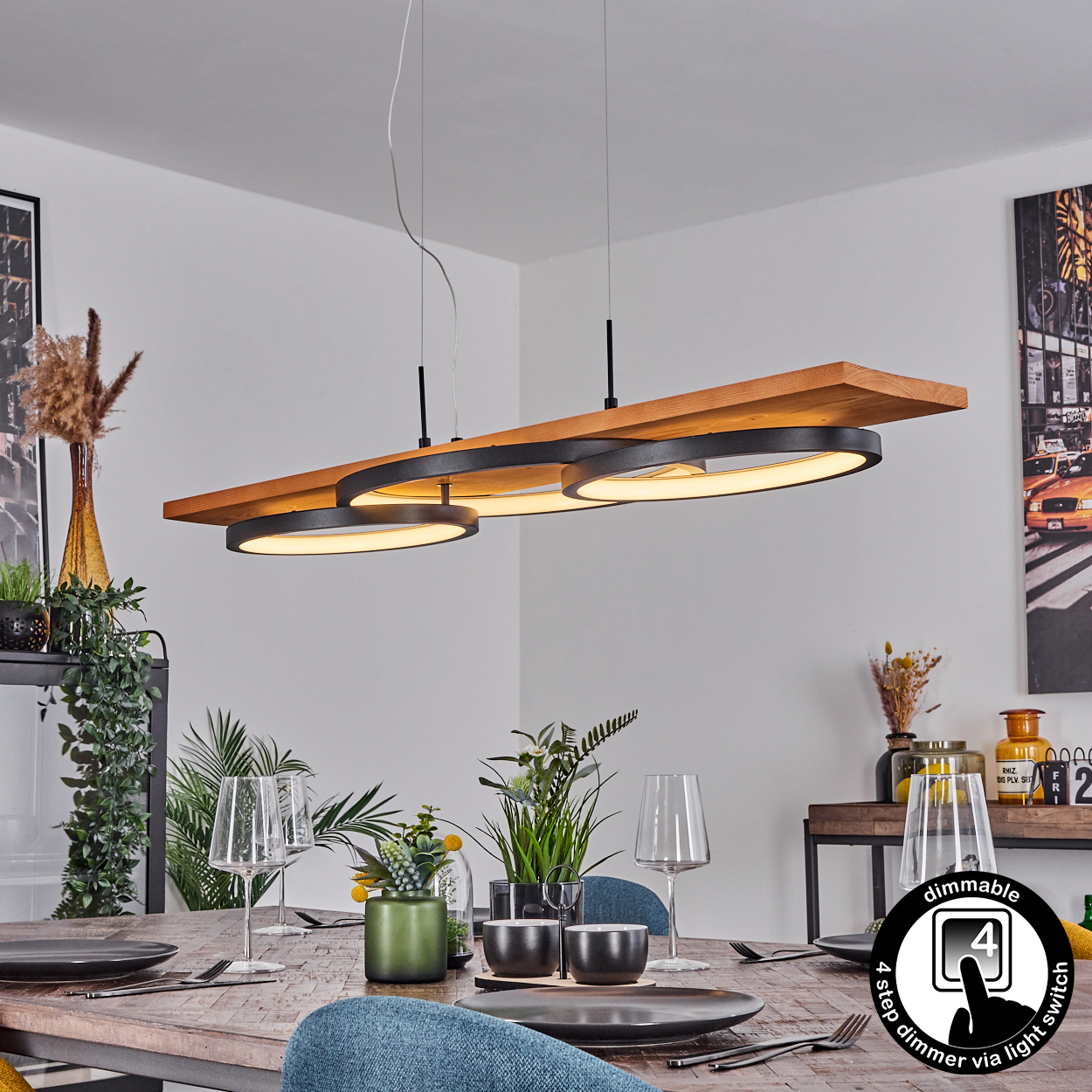 Ein modernes Esszimmer mit Holztisch, Stühlen und stilvollem Kronleuchter. Teller, Gläser und Pflanzen stehen auf dem Tisch.