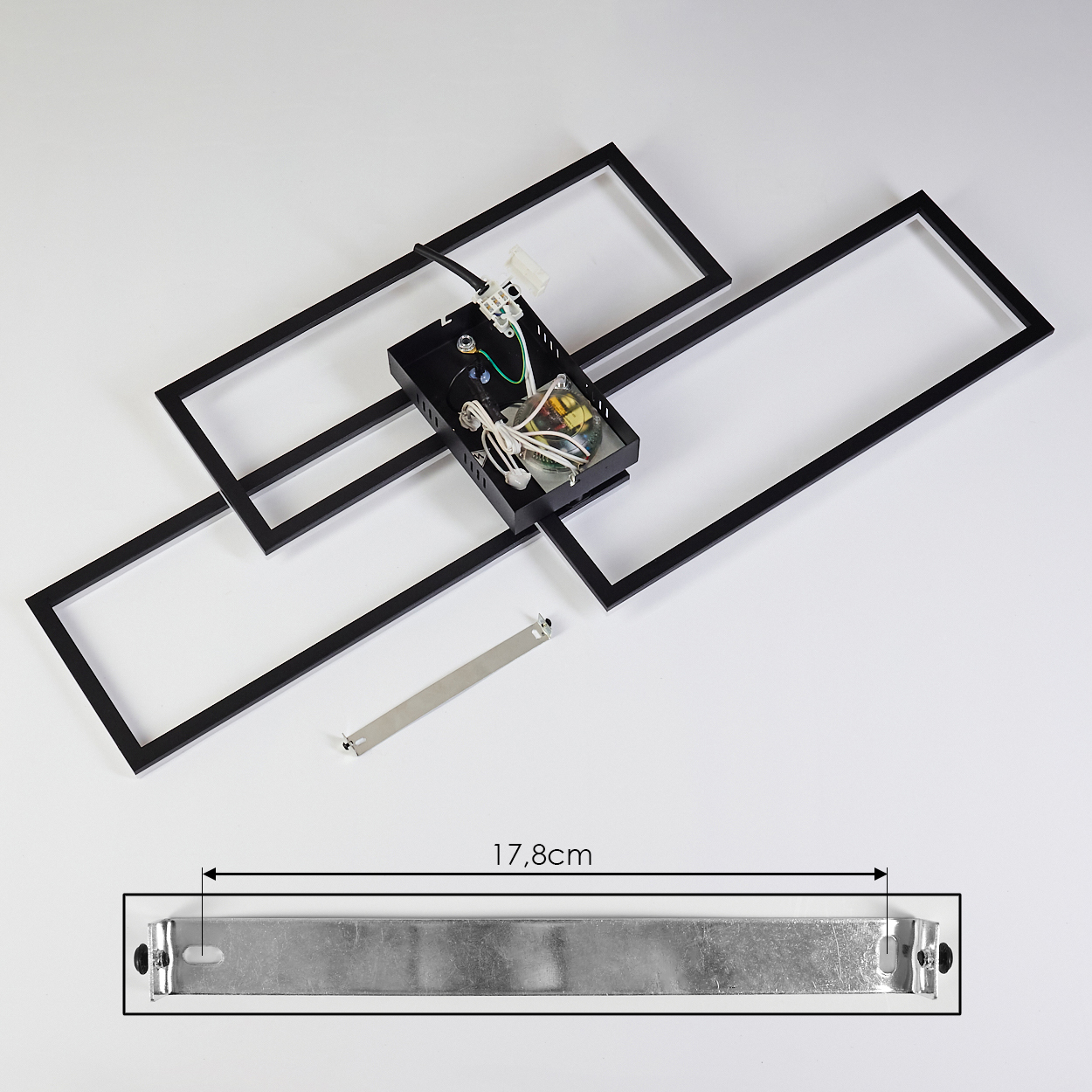 Zerlegte schwarze geometrische Leuchte mit Drähten und Metallhalterung auf weißer Oberfläche. Eine Messung von 17,8 cm wird angezeigt.