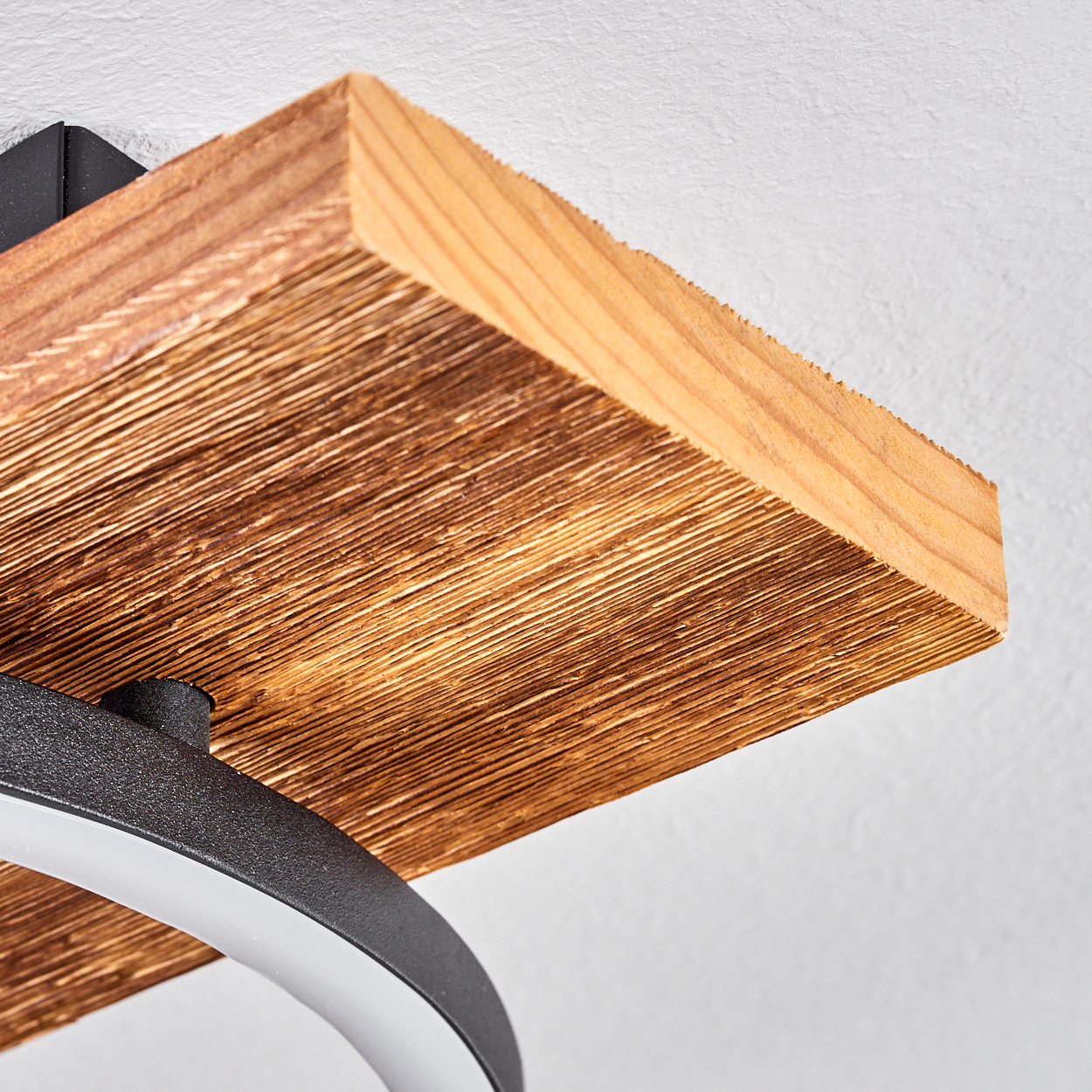 Nahaufnahme eines Holzregals mit einer Leuchte. Das Regal ist braun und an einer weißen Wand befestigt. Unten befindet sich ein gebogenes, weißes Licht.