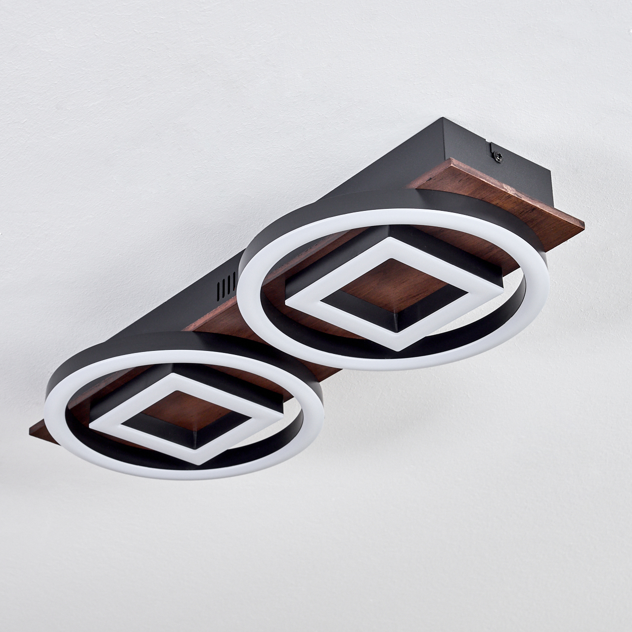 Moderne Deckenleuchte mit zwei kreisförmigen Lichtern und rautenförmiger Mitte. Schwarz, Weiß und Holzfarben.