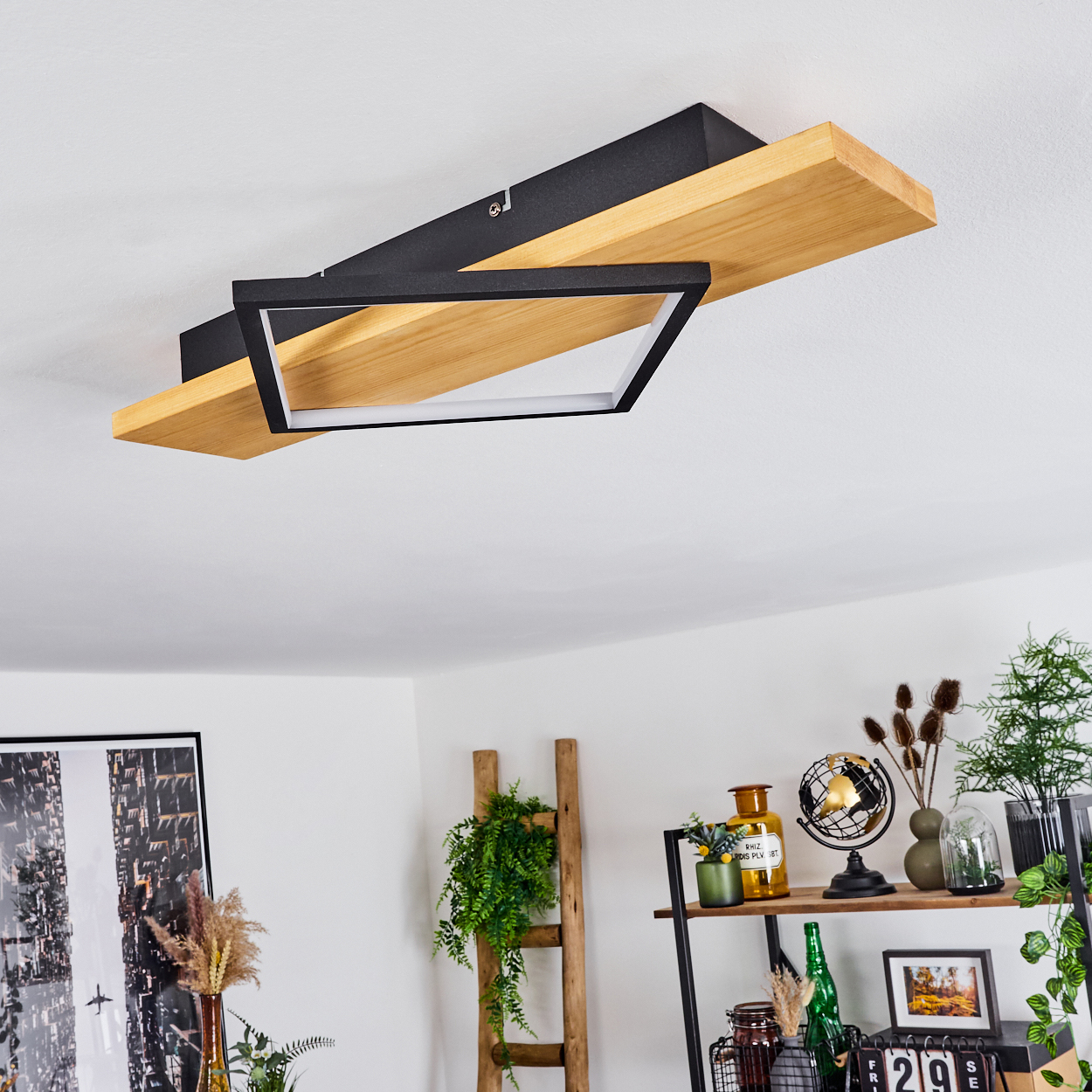 Moderne Deckenleuchte mit Holz- und schwarzem Design. Im Hintergrund ein Regal mit Dekoration.