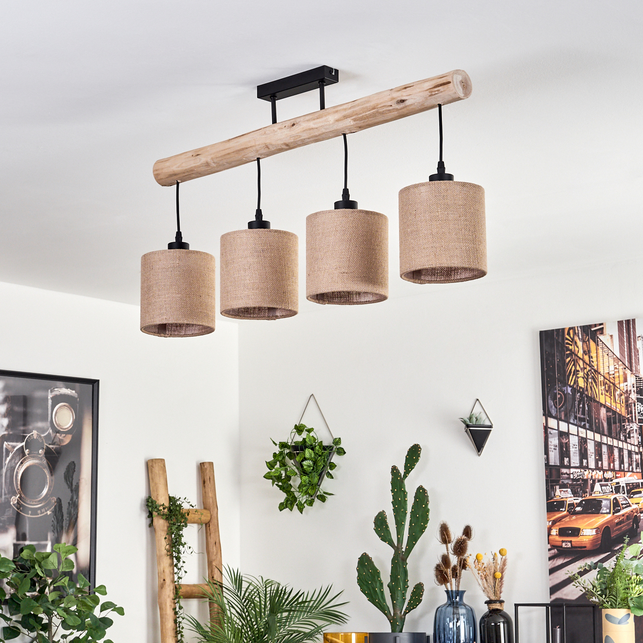 Eine Deckenleuchte mit vier Lampenschirmen hängt über einem Raum mit Pflanzen und Kunst. Eine Holzleiter und ein Stadtbild sind sichtbar.