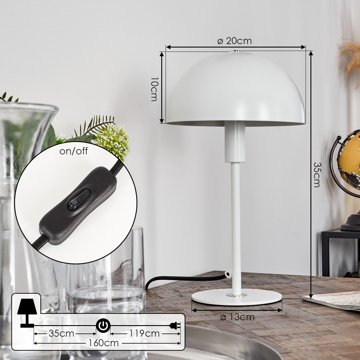 Eine weiße Schreibtischlampe steht auf einem Holztisch. Sie hat einen kuppelförmigen Schirm und einen runden Fuß. Maße sind angegeben.