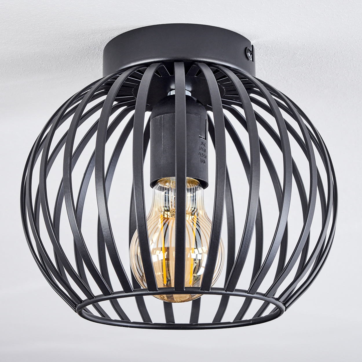 Eine schwarze Deckenleuchte aus Metall mit einer Glühbirne im Inneren. Das Licht ist an einer weißen Decke montiert.