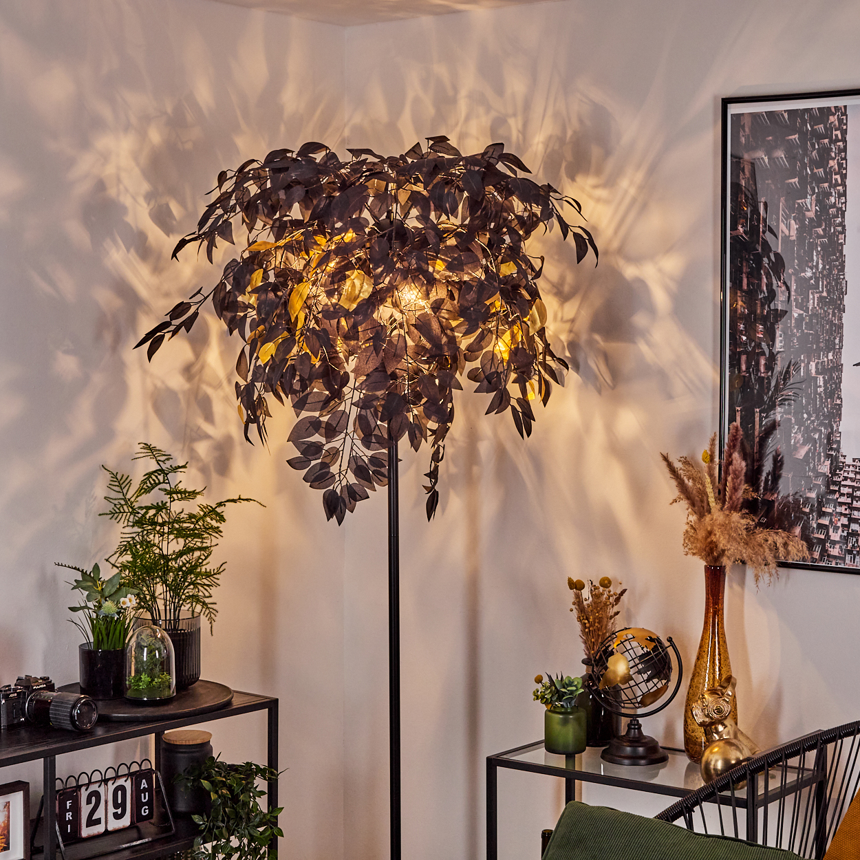 Ein Raum mit einer baumförmigen Lampe. Pflanzen, Dekorationen und ein Bild an der Wand schaffen eine gemütliche Atmosphäre. Schatten an der Wand.
