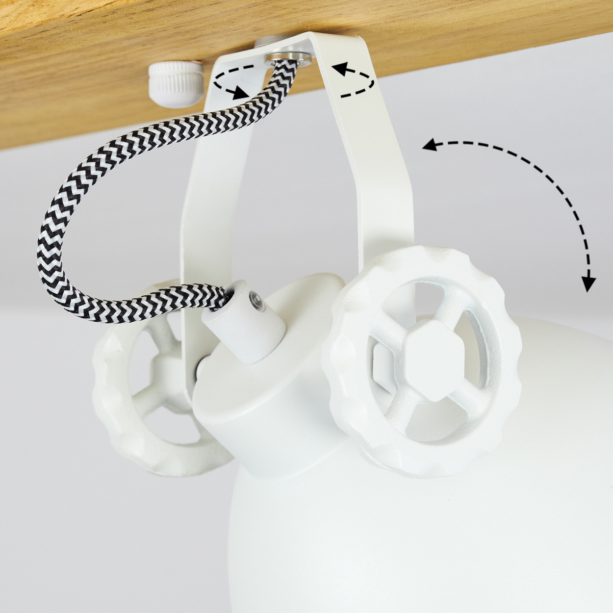 Weiße Lampenhalterung mit schwarz-weißem Kabel. Verstellbarer Arm mit Rad. Auf Holzoberfläche montiert. Pfeile zeigen die Bewegung an.