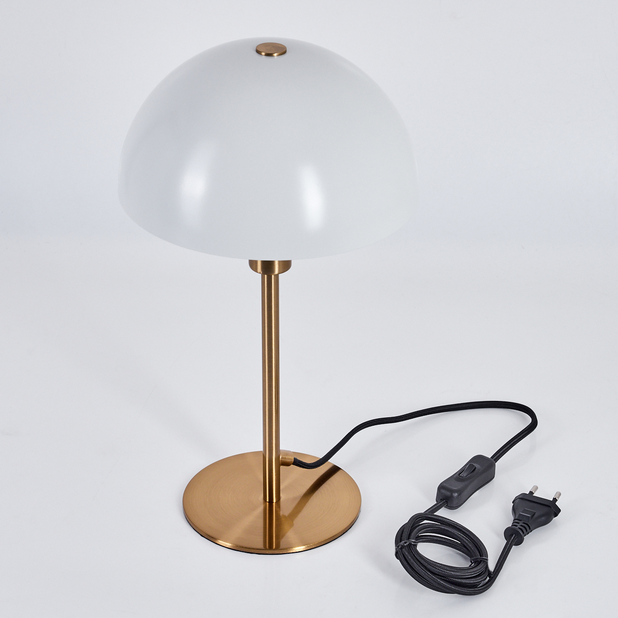 Eine weiße Kuppellampe mit goldenem Ständer und Sockel. Ein schwarzes Netzkabel mit Schalter und Stecker ist angeschlossen.