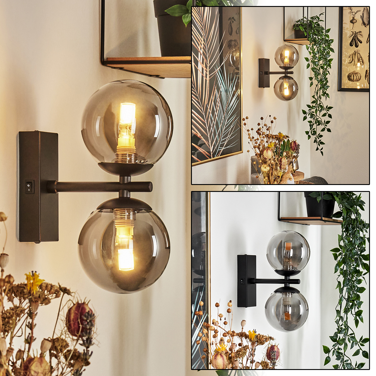 Wandlampen mit Glaskugeln. Schwarze Metallbefestigungen mit zwei kugelförmigen Glasschirmen. Trockenblumen und Pflanzen im Hintergrund.