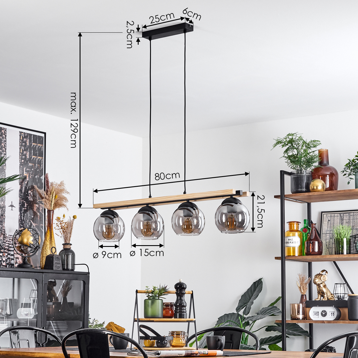 Ein modernes Esszimmer. Ein Holztisch ist mit einer schwarzen Lampe mit 4 Glaskugeln gedeckt, Abmessungen sind angegeben. Regale mit Pflanzen.