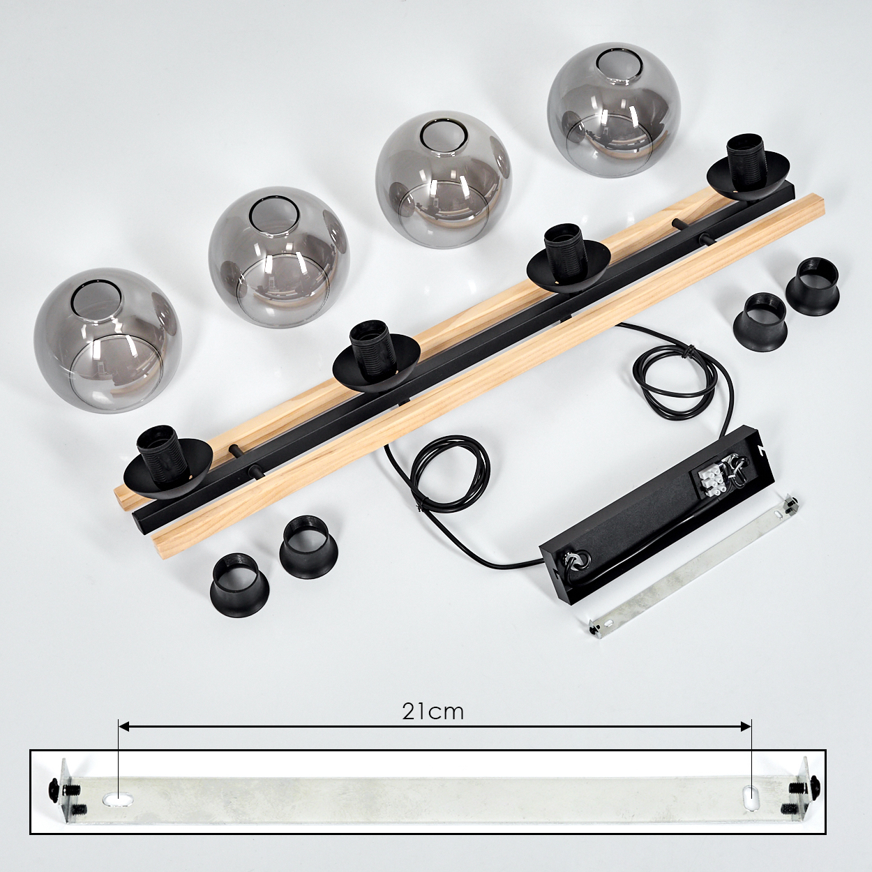Draufsicht auf eine zerlegte Leuchte. Enthält Holzbalken, schwarze Armaturen, Glaskugeln, Verkabelung und eine Metallhalterung.
