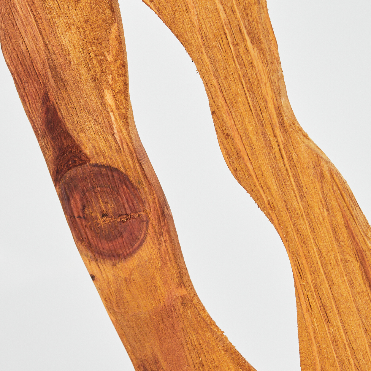 Nahaufnahme von zwei wellenförmigen Holzstücken mit weißem Hintergrund. Das Holz ist hellbraun mit dunkleren Knoten und Maserung.