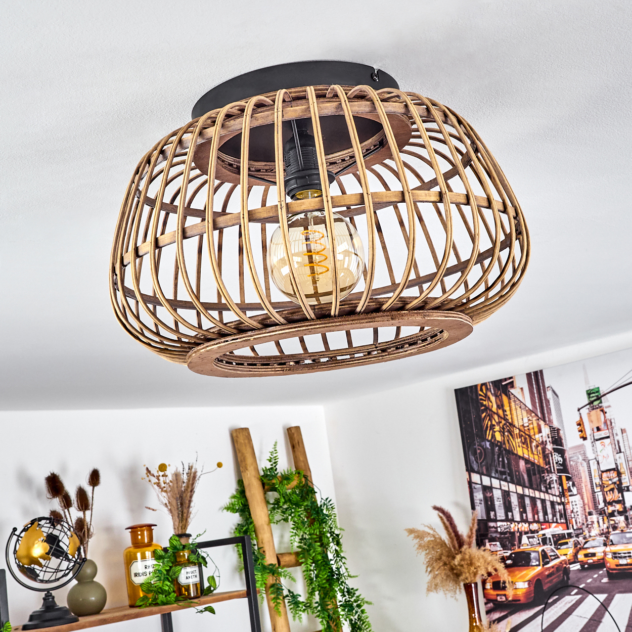 Ein Lampenschirm aus Weide mit einer Glühbirne hängt von der Decke. Darunter zeigt ein Regal Dekoration, und ein New York City Bild hängt.