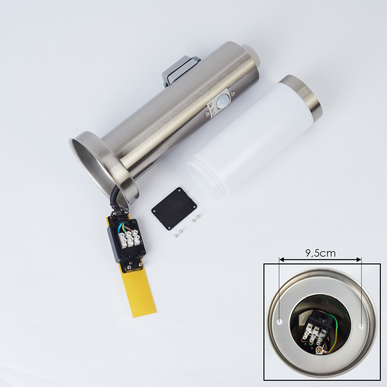 Zerlegte silberne und weiße Lampenteile auf weißem Untergrund. Enthält einen zylindrischen Körper, einen weißen Behälter und elektrische Komponenten.