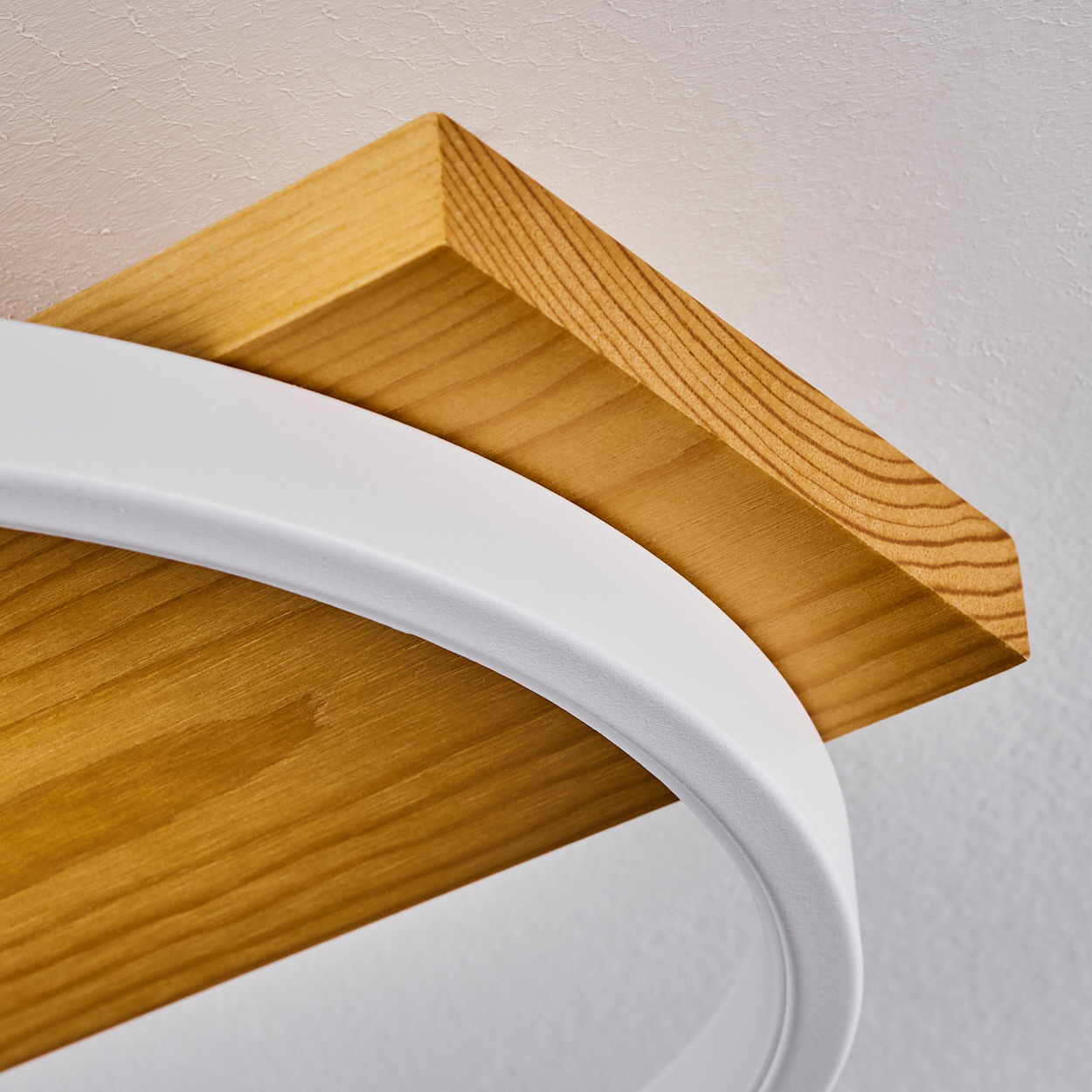 Nahaufnahme eines Holzregals mit weißer Metallstütze. Das Regal ist hellbraun und die Stütze ist gebogen.