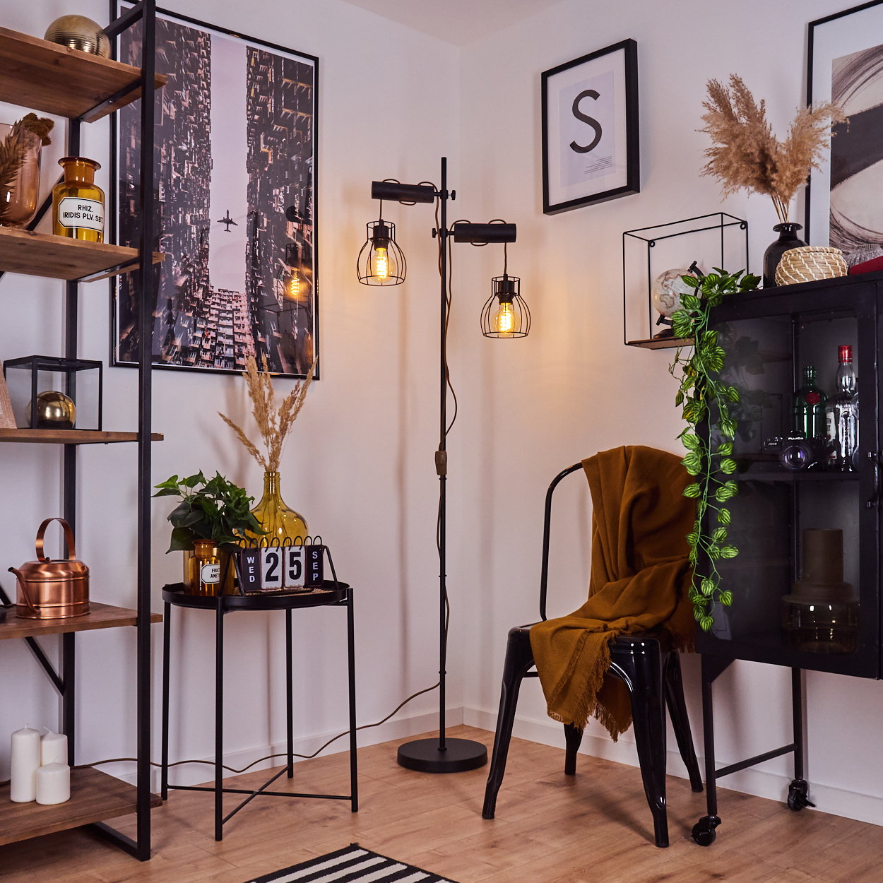 Ein Zimmer mit schwarzer Lampe, Stuhl und Schrank, einem Regal mit Gegenständen und einem Tisch mit Kalender.
