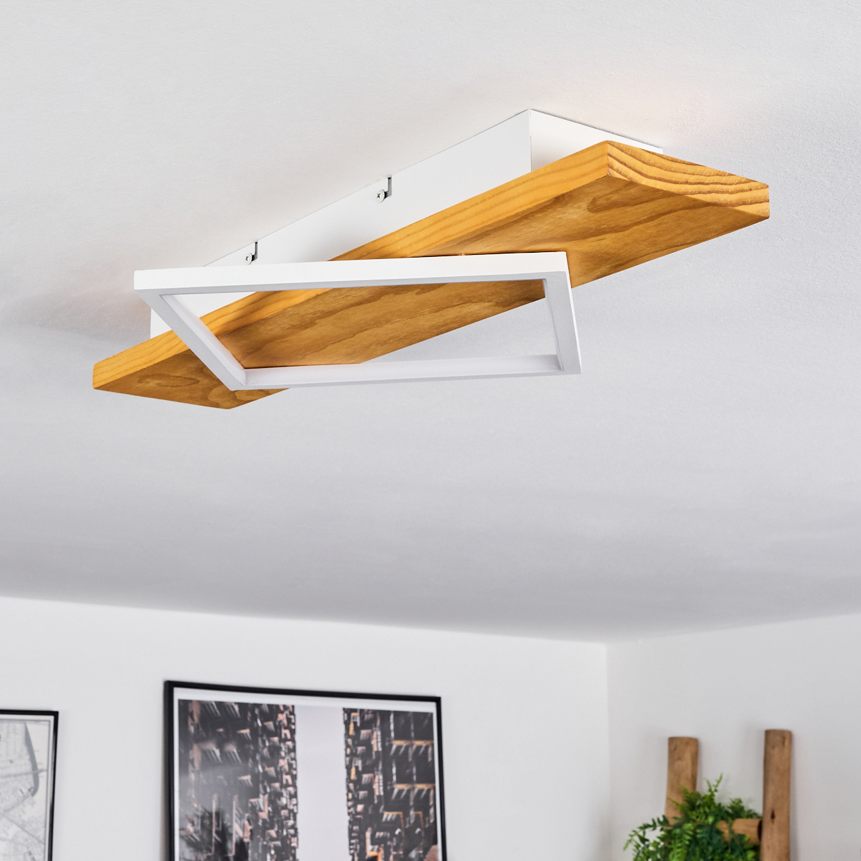Eine Deckenlampe mit Holz- und weißen Elementen. Ein Holzbrett mit weißem Rahmen. Die Szene ist in einem Raum.