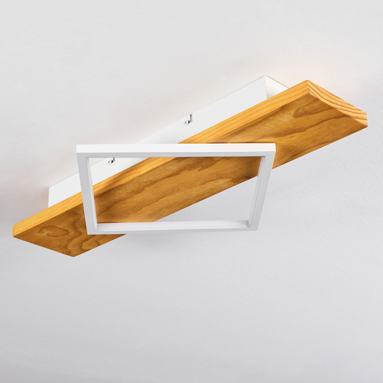 Moderne Deckenlampe. Sie hat einen Holzbalken mit weißem Rahmen und einem weißen Quadrat. Der Hintergrund ist eine weiße Decke.