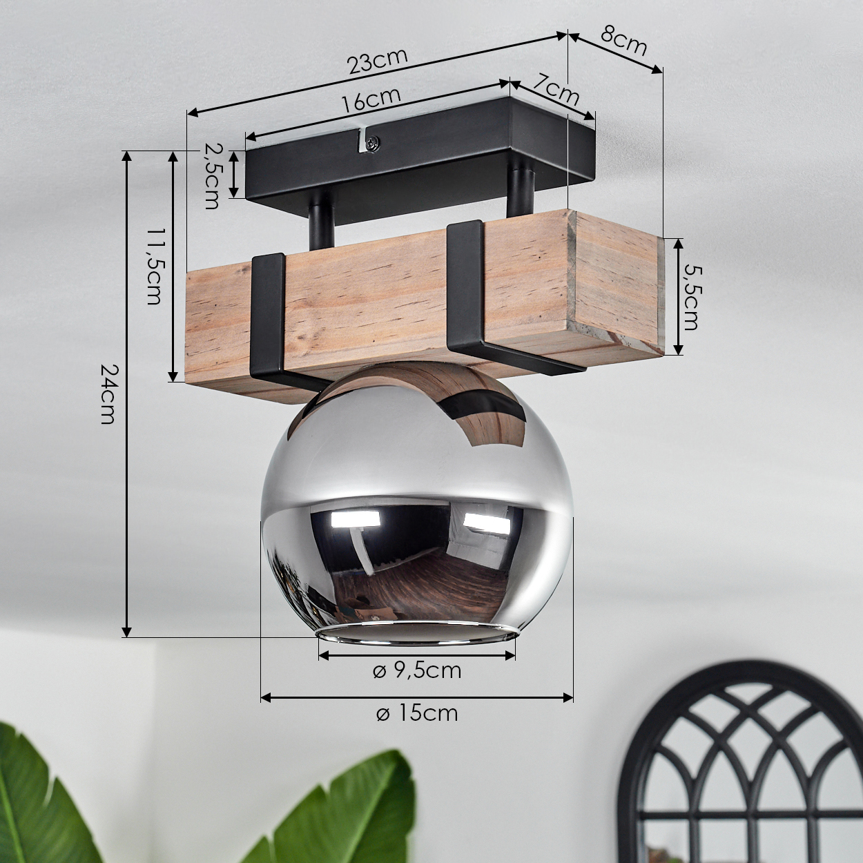 Eine Deckenlampe mit Holzbalken, schwarzen Metallakzenten und einer Chromkugel. Abmessungen sind mit Pfeilen und Maßen angegeben.