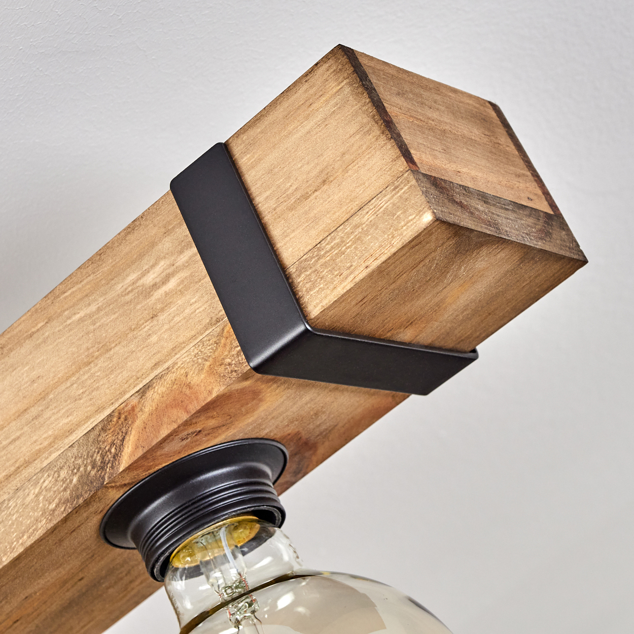 Holzbalken-Leuchte mit schwarzem Metallbügel und Vintage-Glühbirne. Weißer Hintergrund.