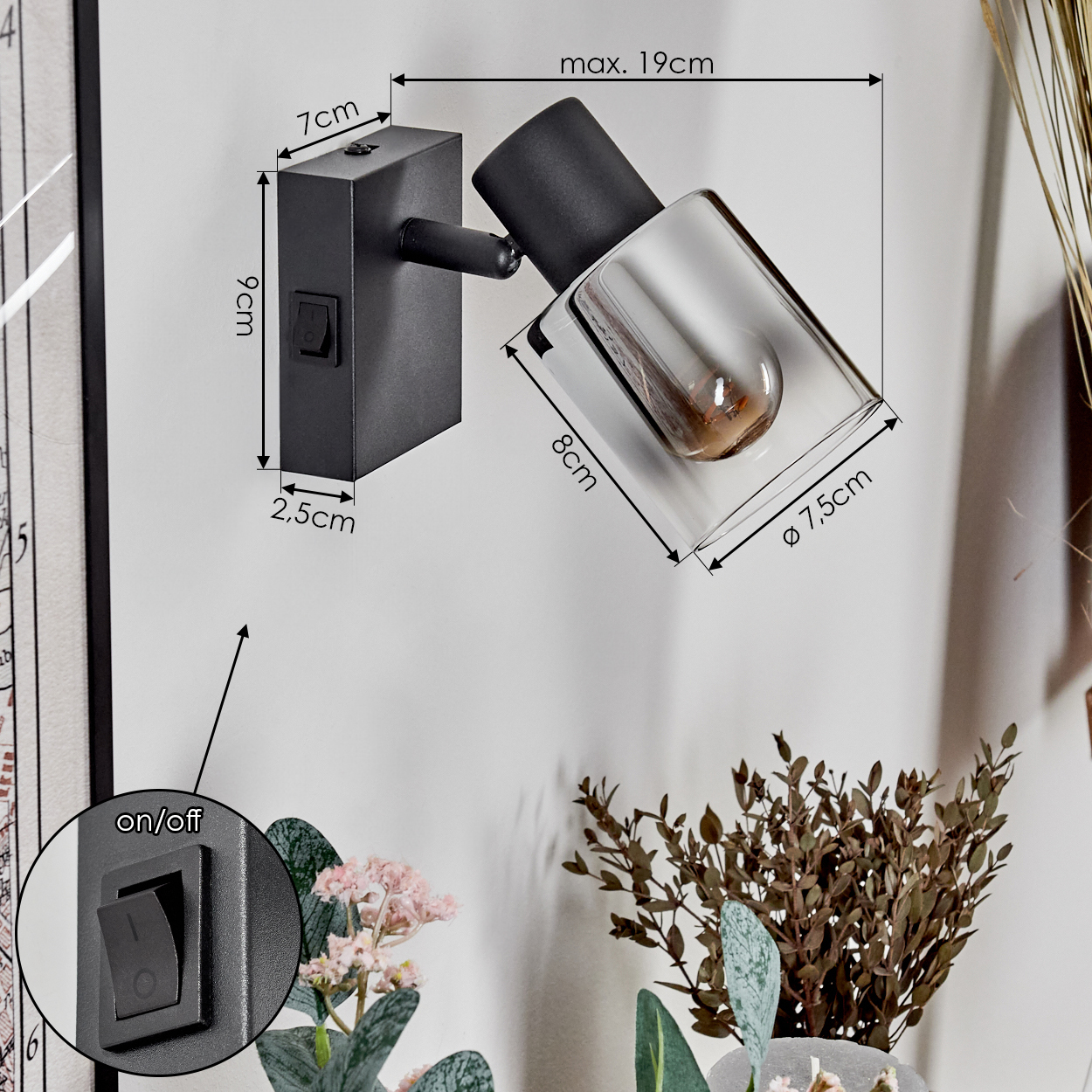 Schwarze Wandleuchte mit Maßen, Ein/Aus-Schalter und Glasschirm. Der Hintergrund hat Pflanzen und eine Wand.