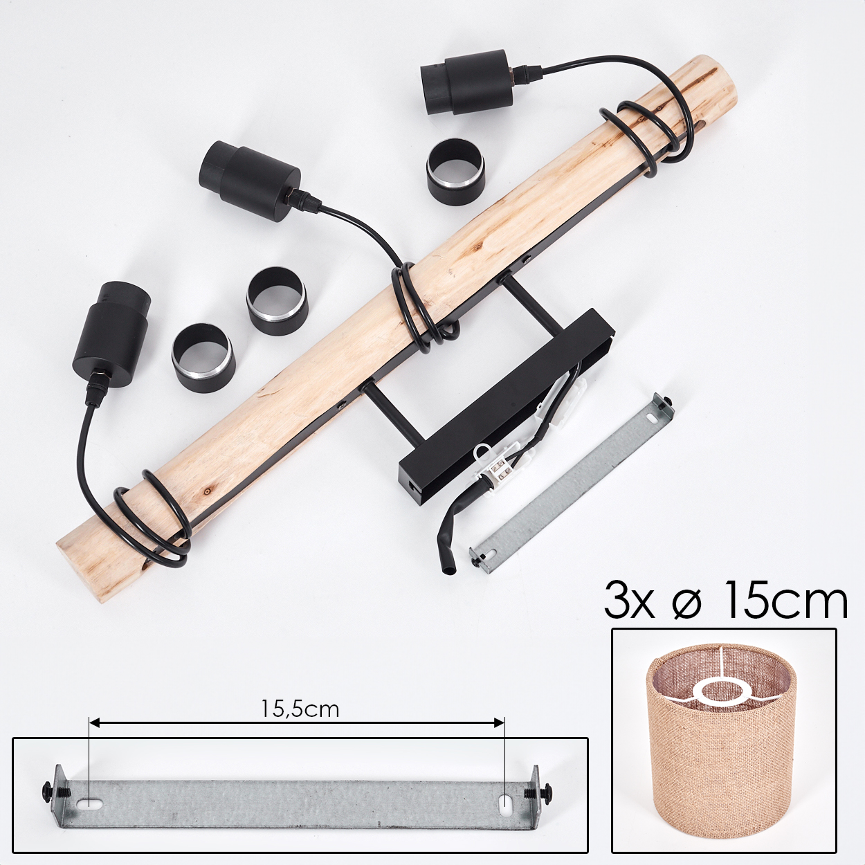 Eine zerlegte Lampe mit Holzbalken, schwarzen Armaturen und einem zylindrischen Lampenschirm. Teile liegen auf einer weißen Oberfläche.