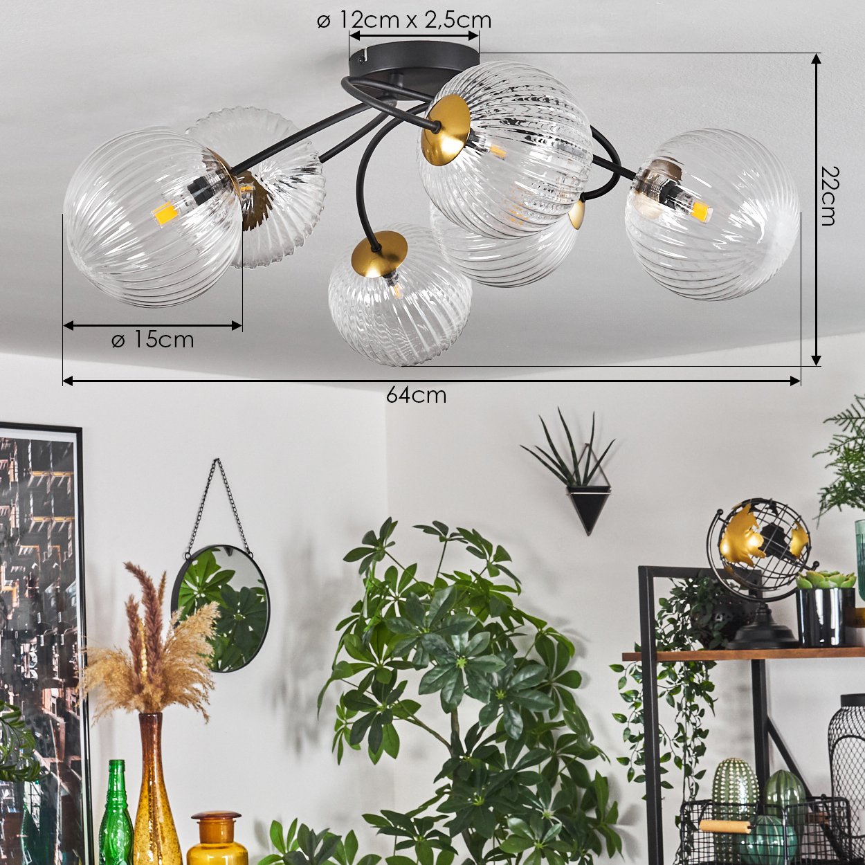 Eine moderne Deckenlampe mit Glaskugeln. Der Hintergrund enthält Pflanzen, Vasen und einen Spiegel.