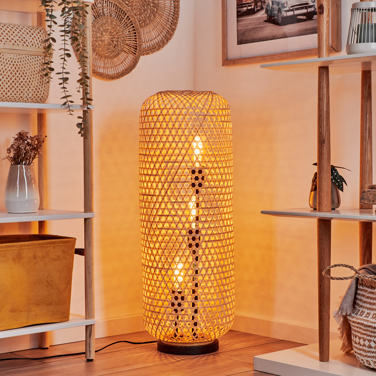Eine Bambuslampe steht in der Ecke und beleuchtet den Raum. Regale mit Dekorationen befinden sich auf beiden Seiten. Geflochtene Körbe und Wanddekoration.