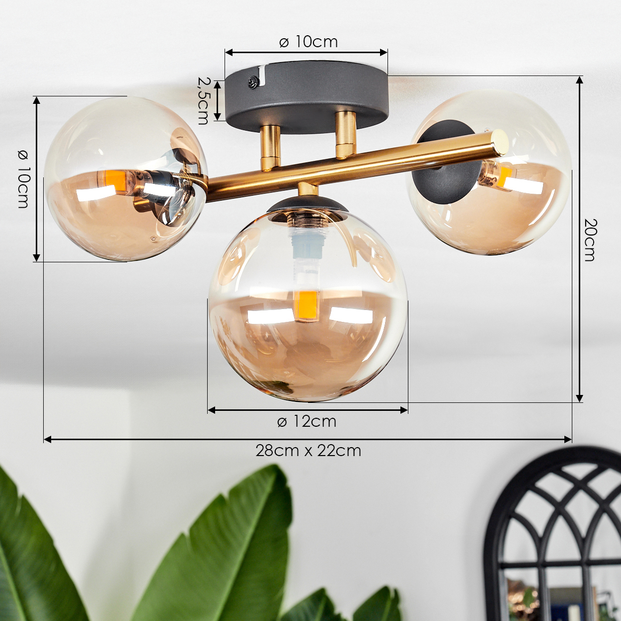 Eine moderne Deckenlampe mit drei kugelförmigen Schirmen. Sie hat einen schwarzen Sockel und einen goldenen Arm. Abmessungen sind angegeben.