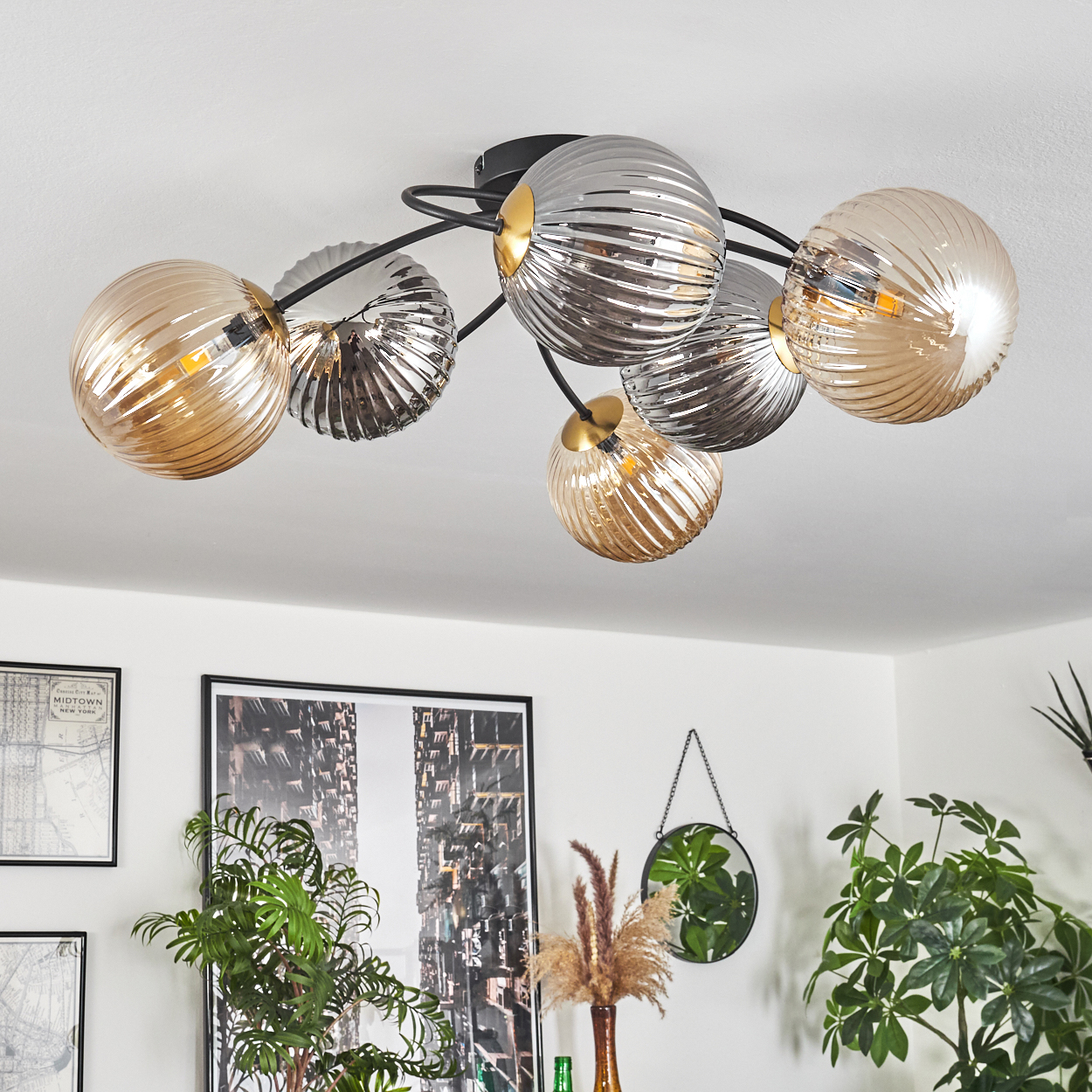 Deckenleuchte mit Glaskugeln. Inneneinrichtung mit Kunstwerken, Pflanzen und einem Spiegel. Modernes Wohnzimmer.