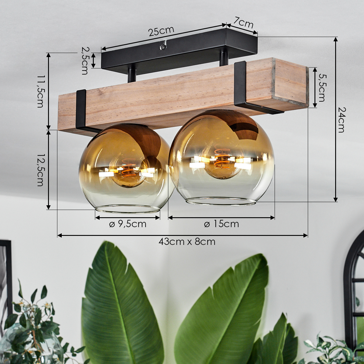 Deckenleuchte mit zwei Glaskugeln, Holzbalken und schwarzen Metallakzenten. Abmessungen sind mit Pfeilen angegeben.