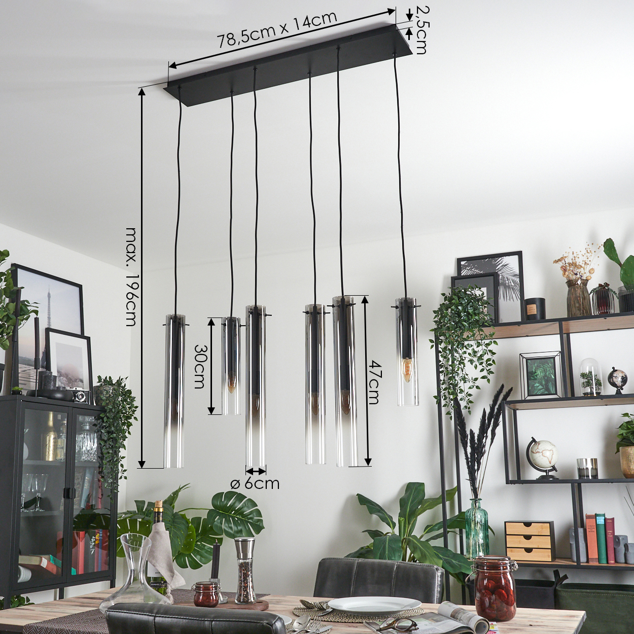 Modernes Esszimmer. Über einem Tisch hängt eine schwarze Leuchte. Pflanzen und Dekoration im Hintergrund. Abmessungen sind angegeben.