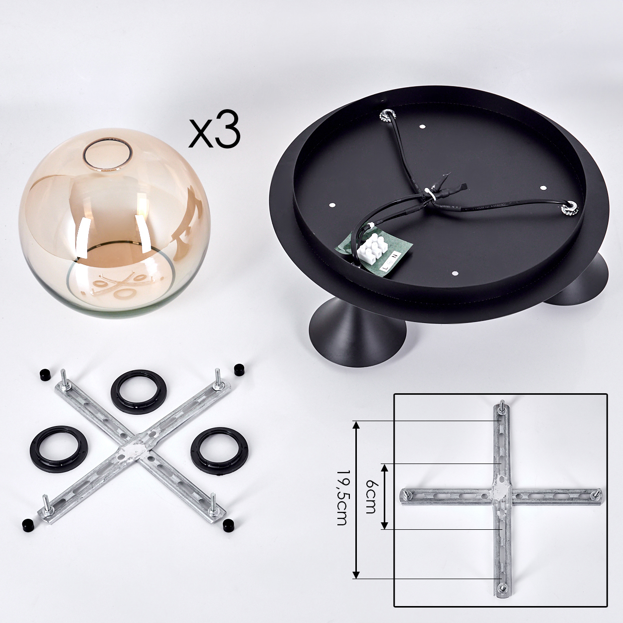 Bestandteile einer Lampe: schwarzer Sockel, Glaskugel, Metallkreuz und Maße.