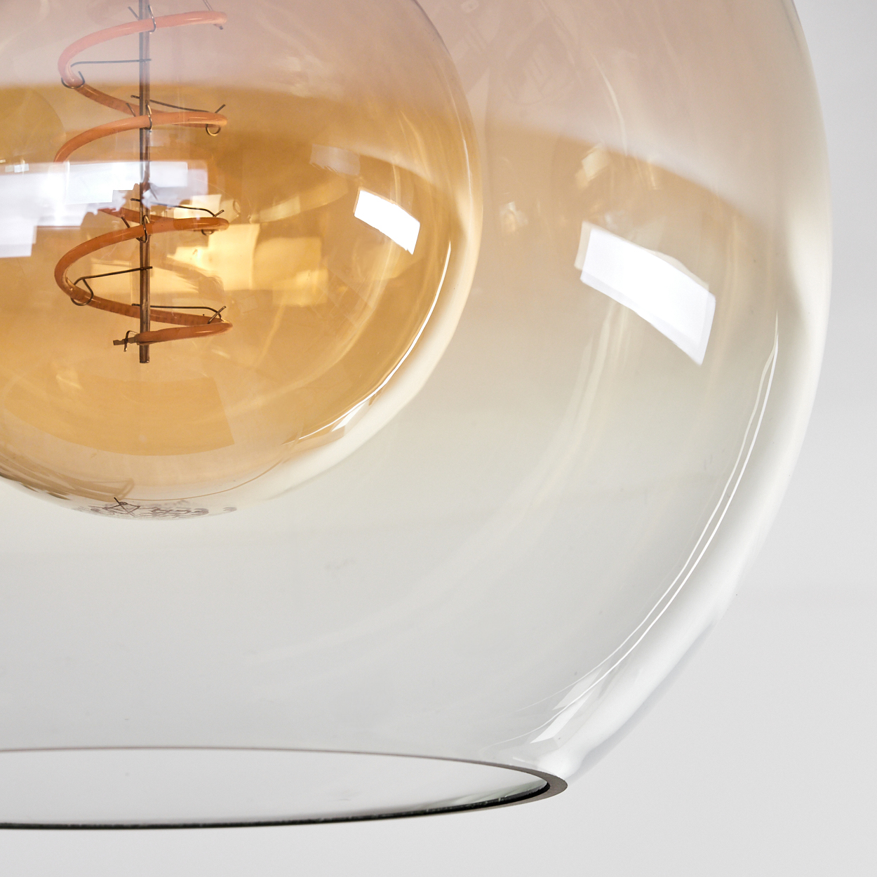 Nahaufnahme einer Glühbirne. Die Birne ist in klarem Glas eingeschlossen. Im Inneren ist ein Spiralfilament sichtbar.