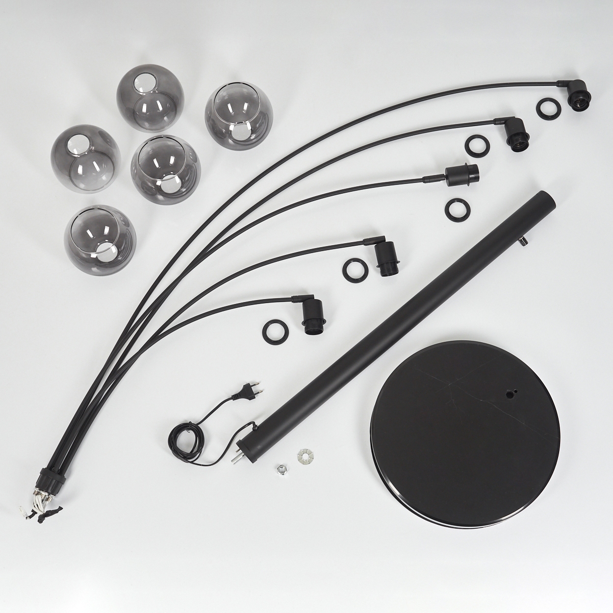 Zerlegte schwarze Stehlampe auf Weiß. Enthält Sockel, Stange, gebogene Arme, Glasschirme und elektrische Komponenten.