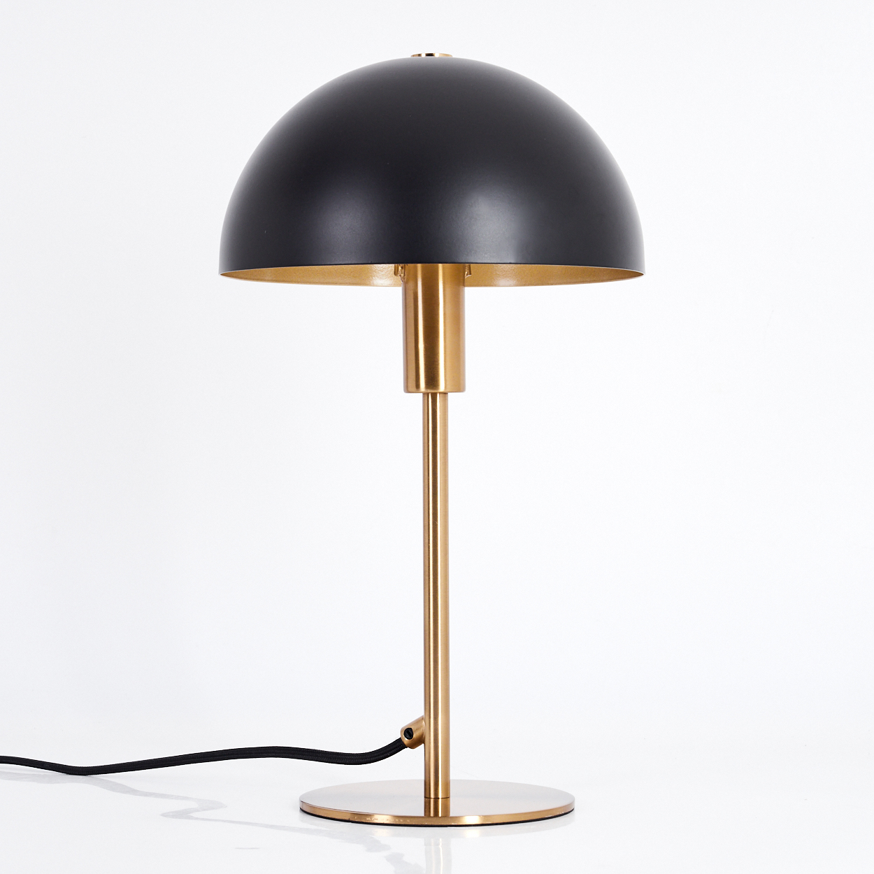 Eine schwarz-goldene Schreibtischlampe mit einem kuppelförmigen Schirm. Der Fuß und der Stiel sind goldfarben, mit einem schwarzen Kabel. Auf weißem Hintergrund.