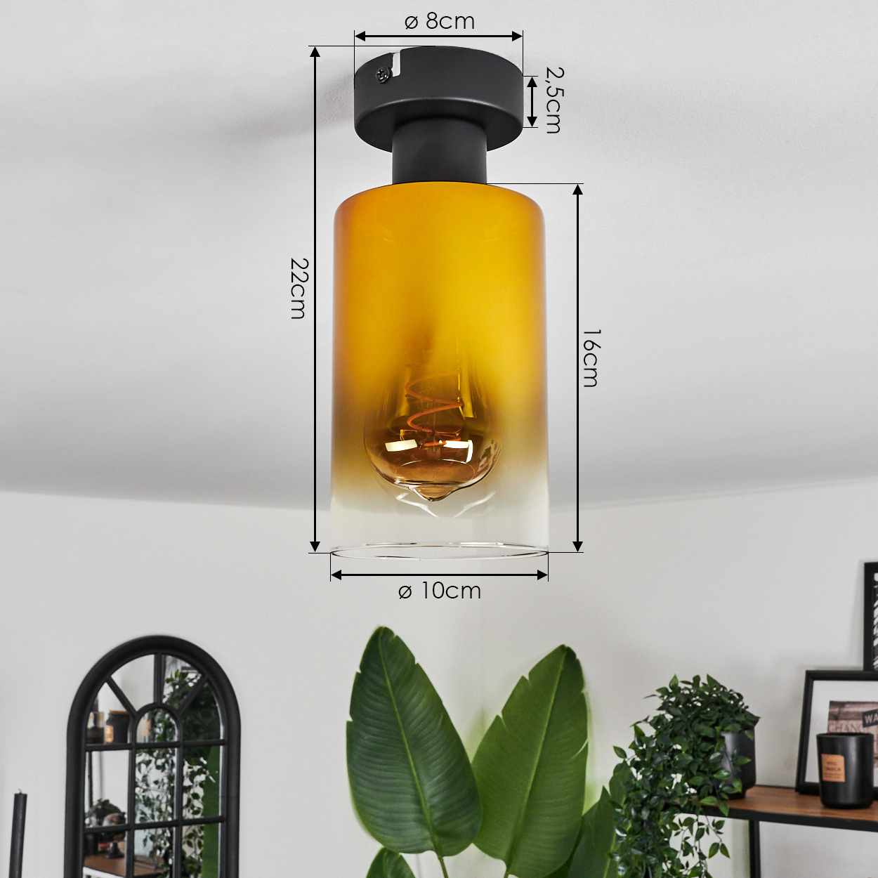 Eine Deckenlampe mit schwarzem Sockel und zylindrischem, bernsteinfarbenem Glasschirm. Abmessungen sind mit Pfeilen angegeben.