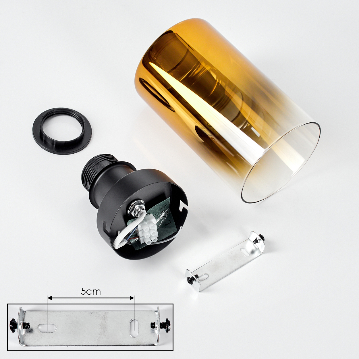 Zerlegte Lampenteile: ein schwarzer Sockel, ein goldbrauner Glasschirm, ein schwarzer Ring, eine Metallhalterung und ein 5cm-Messanzeiger.