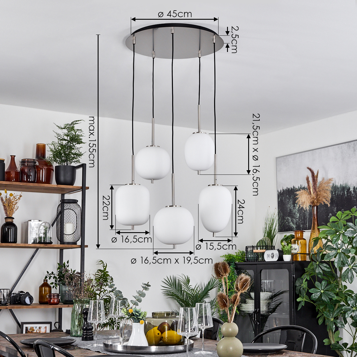 Ein modernes Esszimmer. Eine Hängelampe mit fünf weißen Kugeln hängt über einem Tisch, der zum Essen gedeckt ist. Regale und Pflanzen sind im Hintergrund.