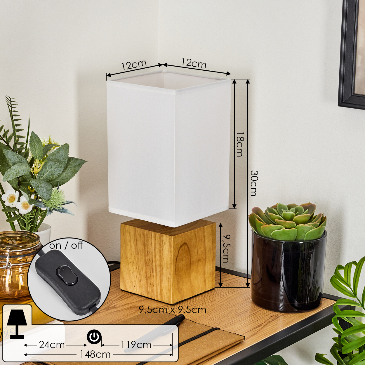 Eine Lampe mit weißem Schirm und Holzsockel, neben einer Sukkulente in einem schwarzen Topf. Abmessungen mit Etiketten versehen.