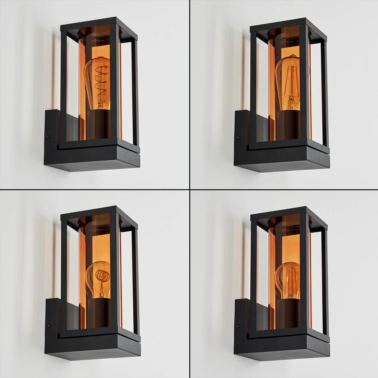 Vier schwarz gerahmte Wandlampen mit bernsteinfarbenem Glas und Glühbirnen vor einer weißen Wand. Jede Lampe hat eine quadratische Form.