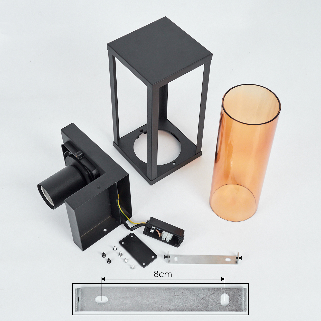 Zerlegte Teile einer schwarzen Außenlampe: Rahmen, Leuchte, bernsteinfarbenes Glas und Befestigungsmaterial, einschließlich einer 8 cm langen Halterung.