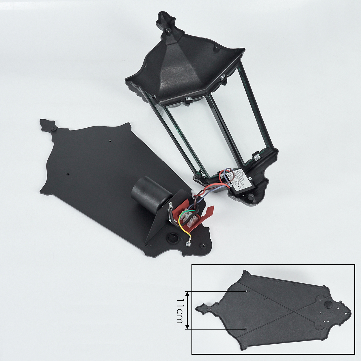 Schwarze zerlegte Laterne mit Glasscheiben. Teile umfassen eine Basis mit Drähten und eine Oberseite. Eine 11 cm Dimension wird gezeigt.