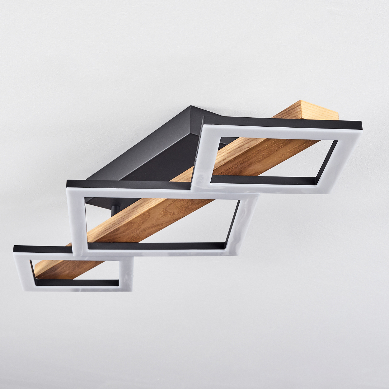 Moderne Deckenleuchte. Merkmale: schwarzes Metall, weiße quadratische Rahmen und Holzbalken an einer weißen Decke.