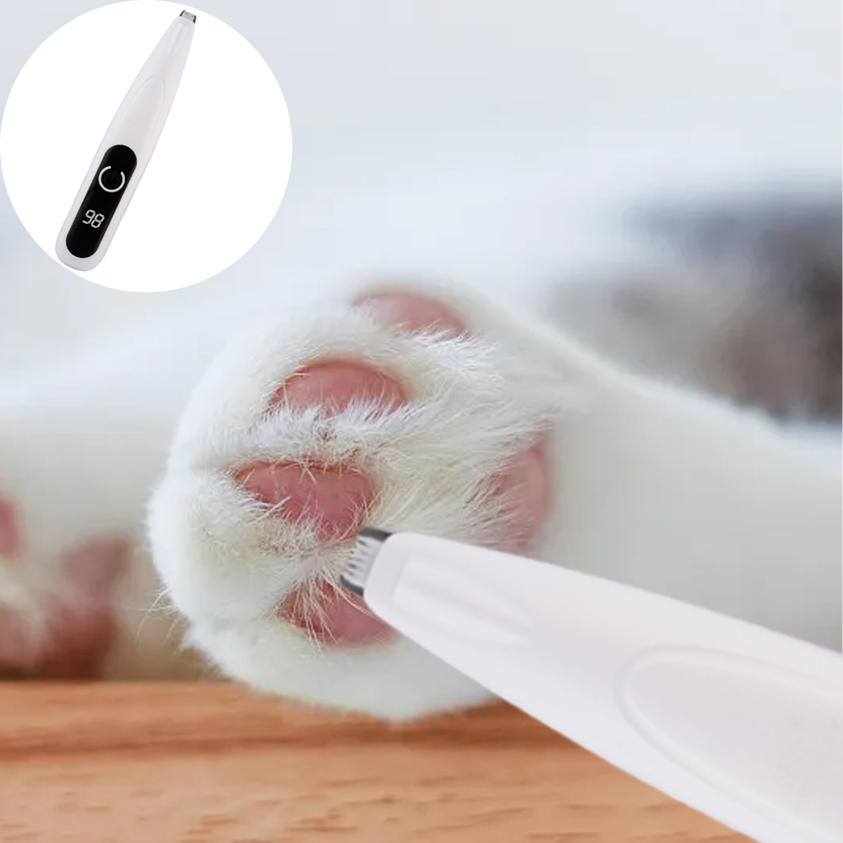Ein weißes Gerät befindet sich in der Nähe einer Katzenpfote. Das Gerät hat einen Bildschirm mit der Anzeige 98. Die Katzenpfote ist weiß mit rosa Polstern.