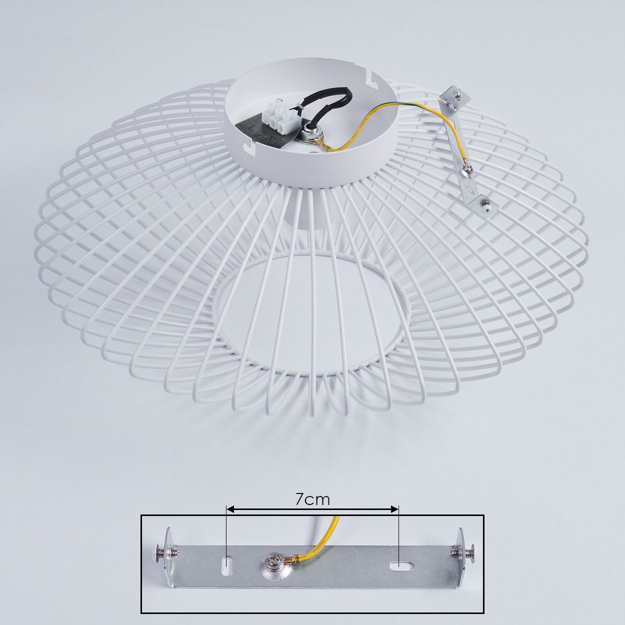 Weißer Drahtrahmen, mit elektrischen Komponenten und einer 7 cm langen Metallhalterung. Drähte in Gelb und Schwarz.