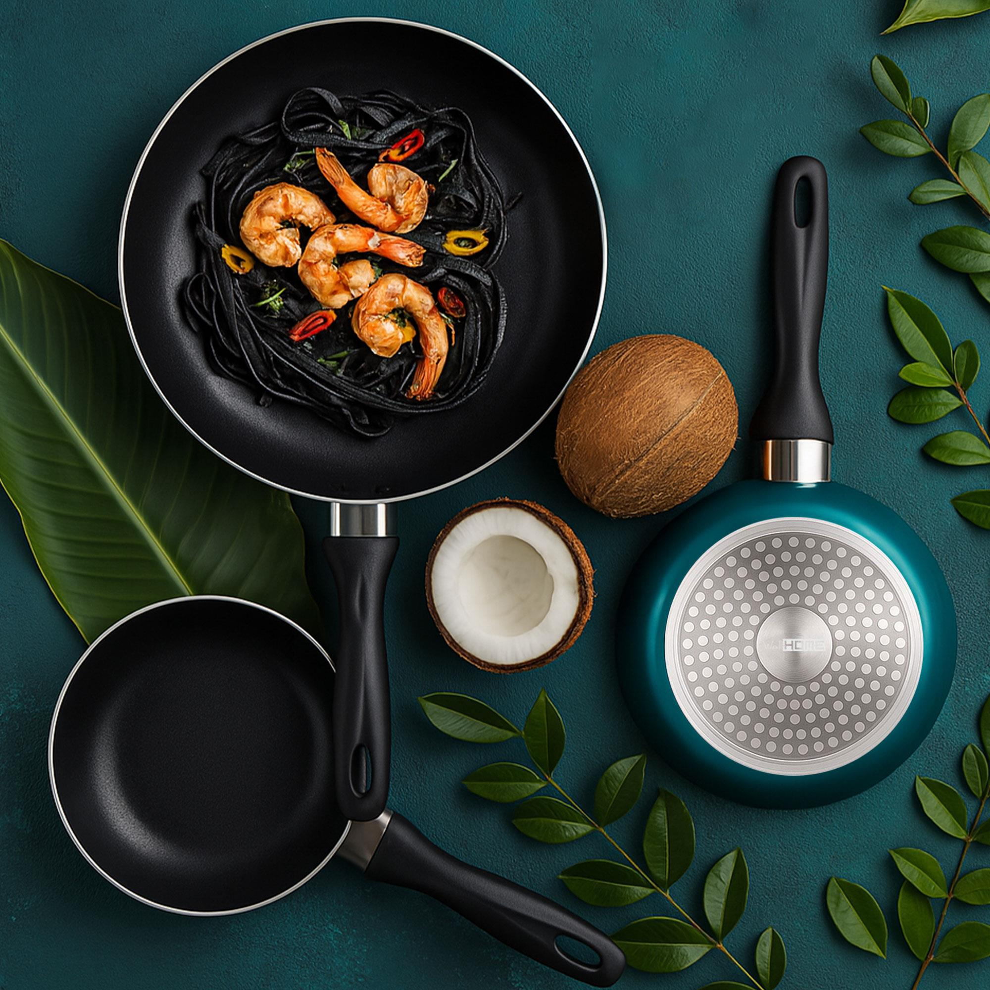 Sartenes con pasta de camarones y coco sobre una superficie verde azulada, rodeadas de hojas.