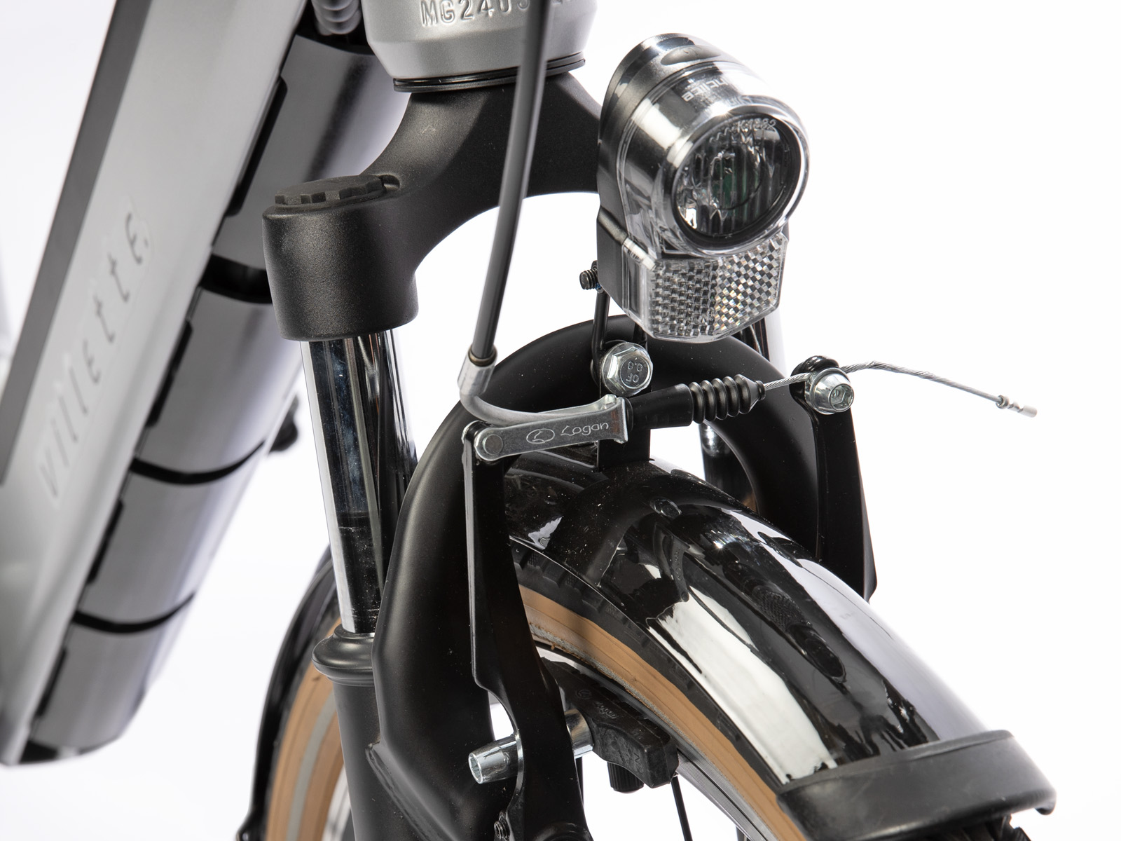 Close-up van de voorkant van een fiets. Inclusief een koplamp, Logan-rem, zwart spatbord en zilveren vork. De band heeft een bruine zijwand.