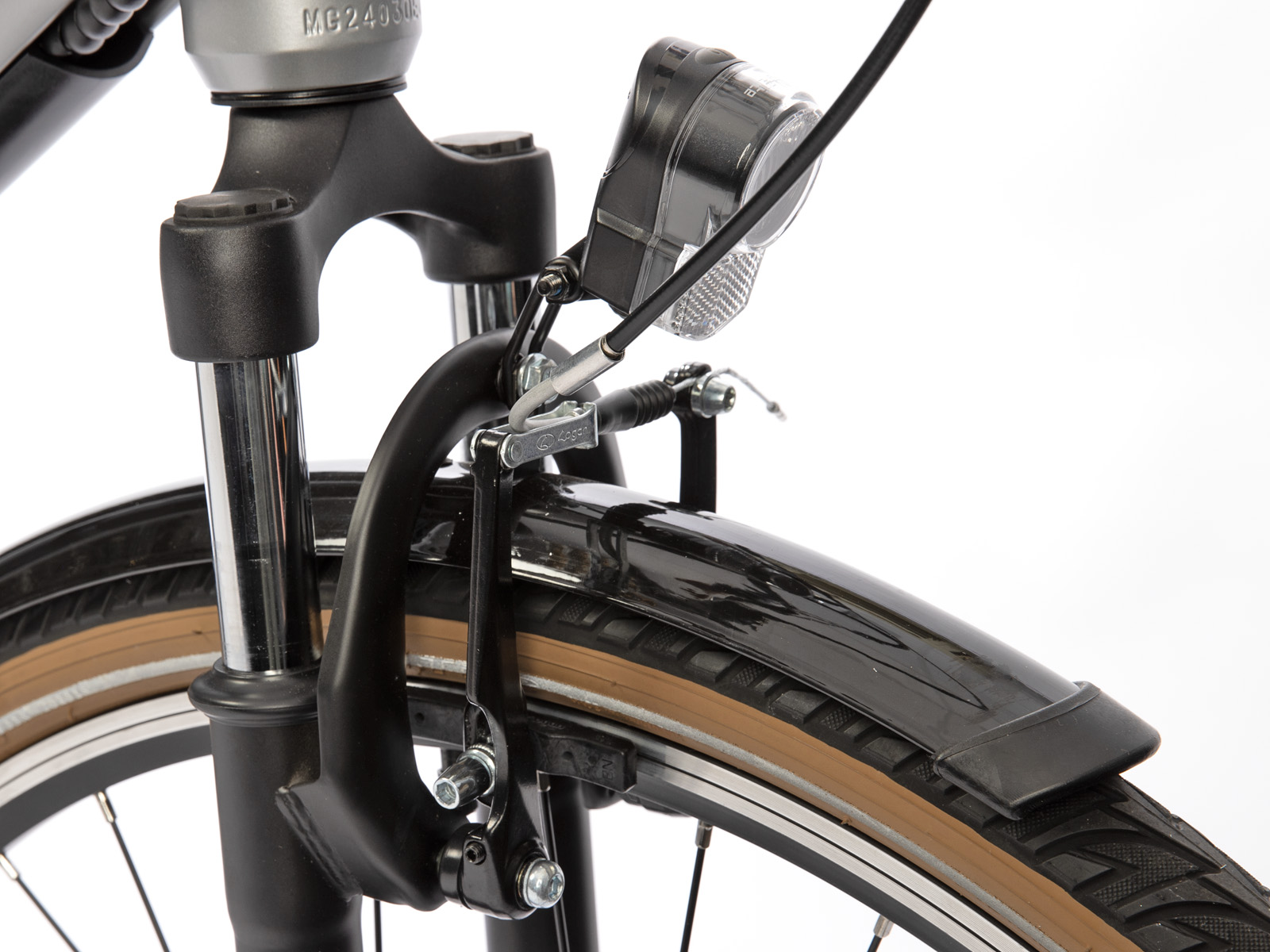 Close-up van de voorkant van een fiets. Details zijn vork, rem, koplamp en deel van de band met bruine zijkant.