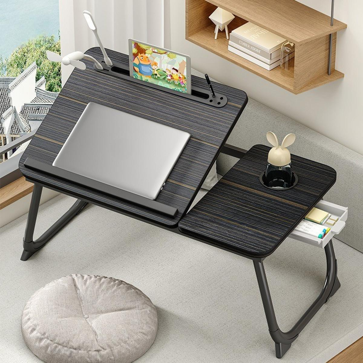 Ein Laptoptisch mit Laptop, Tablet und Hasendekor. Ein kleiner Ventilator und eine Lampe sind angebracht. Ein kleines rundes Kissen liegt auf dem Boden.