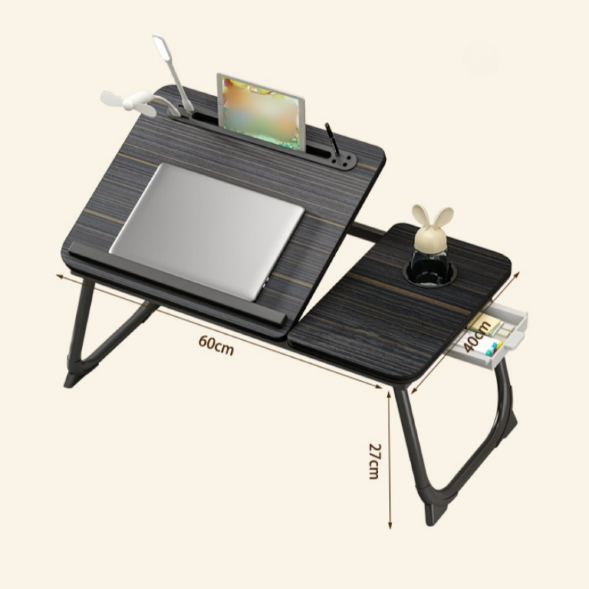 Ein hölzerner Laptop-Schreibtisch mit Laptop, Tablet, Lampe und Ventilator. Er hat einen Getränkehalter und eine kleine Schublade. Abmessungen sind angegeben.